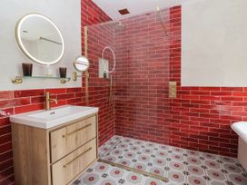 A bathroom with a shower and wooden vanity at Kexby House