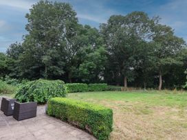 A garden with grass and bushes at Kexby House