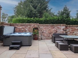 An outdoor area with a hot tub and seating at Kexby House