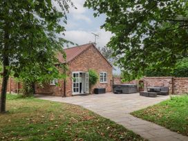 An outdoor area with a brick house and seating at Kexby House in Kexby near Wilberfoss