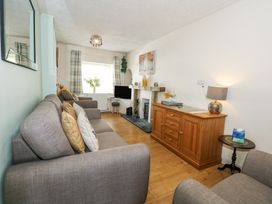 A living room with sofas a wooden cabinet a fireplace and a TV at Cuddfan in Tremadog