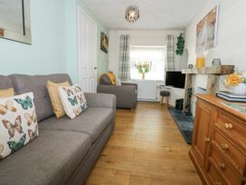 A living room with grey sofas and butterfly cushions at Cuddfan in Tremadog
