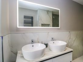 A bathroom with double sinks and a mirror at Beckmead in Windermere