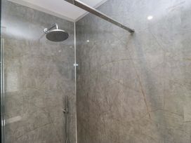 A shower with stone walls and fixtures at Beckmead in Windermere