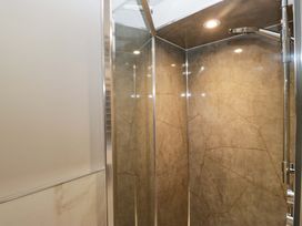 A shower with glass door and stone walls at Beckmead in Windermere