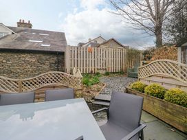 A garden with a table and chairs at Beckmead in Windermere