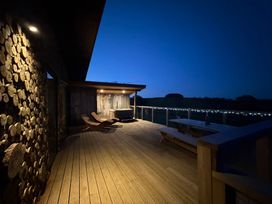 A deck with a hot tub and chairs at Bryn Hafod in Llandrindod Wells