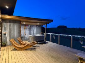 An outdoor area with a hot tub and wooden chairs at Bryn Hafod in Llandrindod Wells