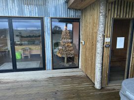 An outdoor area with a Christmas tree visible through glass doors at Llety Cariad in Llandrindod Wells