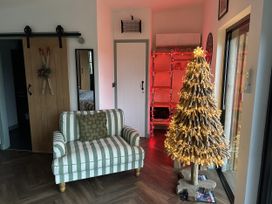 A living room with a sofa and a Christmas tree at Llety Cariad in Llandrindod Wells