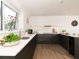 A kitchen with a sink, cabinets, and vegetables at Sandy Cove in Praa Sands