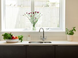 A kitchen with a sink and vegetables on the countertop at Sandy Cove in Praa Sands