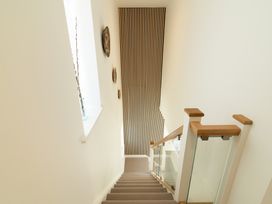 A stairwell with a staircase and decorative wall elements at Sandy Cove in Praa Sands