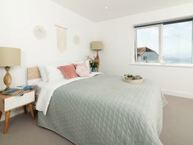 A bedroom with a bed and a window at Sandy Cove in Praa Sands