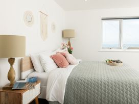 A bedroom with a bed and nightstand at Sandy Cove in Praa Sands