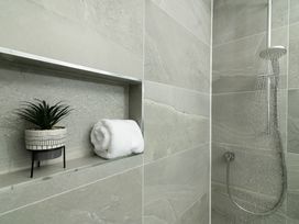 A shower area with a towel and a plant at Sandy Cove in Praa Sands