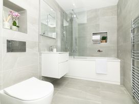 A bathroom with a bathtub, toilet, and vanity at Sandy Cove in Praa Sands