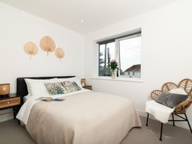 A bedroom with a bed and decorative wall pieces at Sandy Cove in Praa Sands