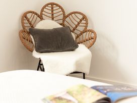 A chair with a cushion and blanket in a living room at Sandy Cove in Praa Sands
