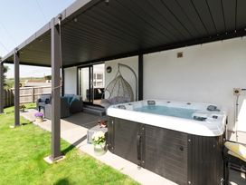 An outdoor area with a hot tub and seating at Sandy Cove in Praa Sands