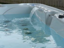 A hot tub with water and jets at Sandy Cove in Praa Sands