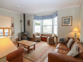 A living room with a sofa and armchairs at Kipper Lodge in Dartmouth