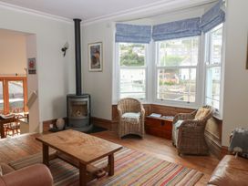 A living room with wicker chairs and a wooden table at Kipper Lodge in Dartmouth