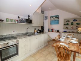A kitchen with appliances and dining table at Kipper Lodge in Dartmouth