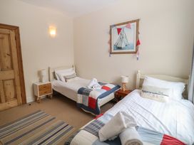 A bedroom with two beds and a nightstand at Kipper Lodge in Dartmouth