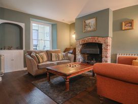 A living room with a fireplace and seating area at The Fernery in Colyton
