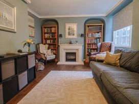 A living room with a sofa and bookshelf at The Fernery in Colyton