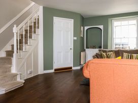 A living room with a staircase and door at The Fernery in Colyton
