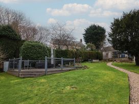 A garden with a deck and lawn at The Fernery in Colyton
