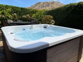 A hot tub with water and outdoor furniture at Holme Fell in Coniston