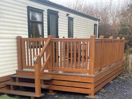 A deck with a railing and steps at Rosehaven Tegryn near Crymych