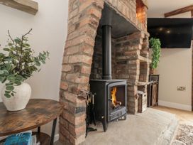 A living room with a fireplace and wood stove at Betsy's Burrow