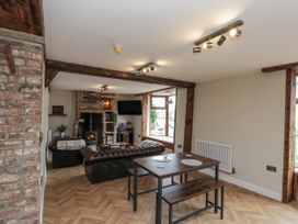 A living room with a fireplace and dining table at Betsy's Burrow