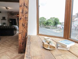 A living room with a window, table, coffee cup, and books at Betsy's Burrow