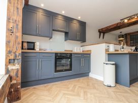 A kitchen with cabinets, oven and microwave at Betsy's Burrow