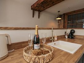 A kitchen with champagne and glasses on wooden countertop at Betsy's Burrow