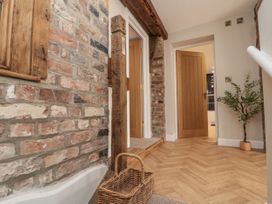 A hallway with brick walls and a basket at Betsy's Burrow