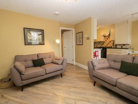 A living room with two sofas and a kitchen area at Jenny's in Hawkshead