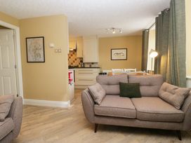 A living room with a sofa and kitchen in view at Jenny's in Hawkshead