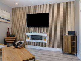 A living room with a television and fireplace at Ty Glan Morfa in Morfa Bychan