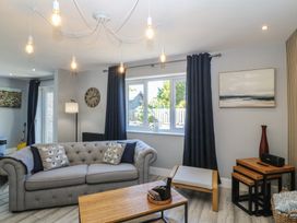 A living room with a sofa, table, and window at Ty Glan Morfa in Morfa Bychan