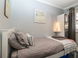 A bedroom with a bed and wardrobe at Ty Glan Morfa in Morfa Bychan
