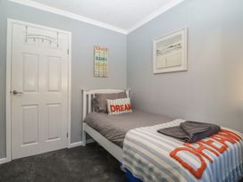A bedroom with a bed and wall art at Ty Glan Morfa in Morfa Bychan