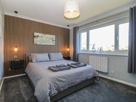 A bedroom with a bed and wall art at Ty Glan Morfa in Morfa Bychan