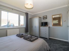 A bedroom with a bed and wardrobe at Ty Glan Morfa in Morfa Bychan
