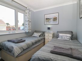 A bedroom with two single beds and a bedside table at Ty Glan Morfa in Morfa Bychan